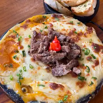 Panela de escondidinho gratinado com carne e pão de alho