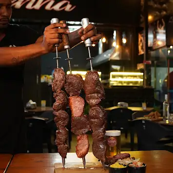 Espetos de carne na brasa servidos no Quintal da Resenha